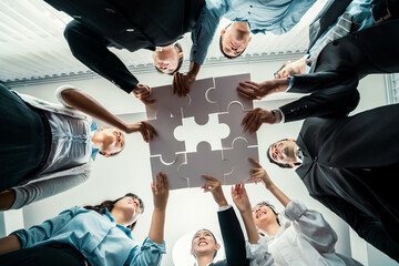 multiethnic business people holding jigsaw pieces and merge them together as effective solution solv