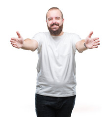 Wall Mural - Young caucasian hipster man wearing casual t-shirt over isolated background looking at the camera smiling with open arms for hug. Cheerful expression embracing happiness.