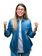 © Krakenimages.com - Young beautiful woman over wearing glasses over isolated background celebrating surprised and amazed for success with arms raised and open eyes. Winner concept.