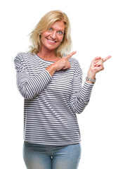 Wall Mural - Middle age blonde woman over isolated background smiling and looking at the camera pointing with two hands and fingers to the side.