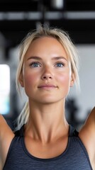 A young woman with blonde hair looks up while working out in the gym.