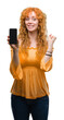 © Krakenimages.com - Young redhead woman showing smartphone screaming proud and celebrating victory and success very excited, cheering emotion