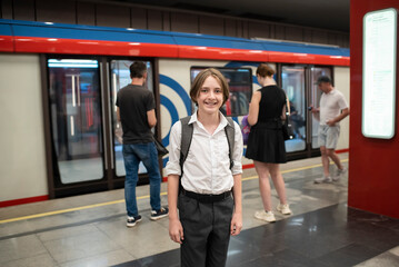 Schoolboy, teenager stands on the platform of the Moscow metro