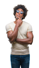 Wall Mural - afro american man wearing sunglasses over isolated background with hand on chin thinking about quest