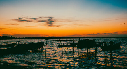 Atardecer, San Antero, Cordoba, ColombiaOrange sunset with silhouettes of people and boats in Cispata Bay. Colombia. 