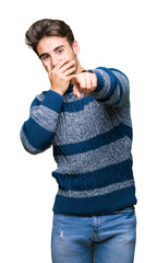 Wall Mural - Young handsome man over isolated background Laughing of you, pointing to the camera with finger hand over mouth, shame expression