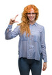 © Krakenimages.com - Young redhead bussines woman smiling and confident gesturing with hand doing size sign with fingers while looking and the camera. Measure concept.