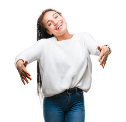 Wall Mural - Young braided hair african american girl wearing winter sweater over isolated background looking at the camera smiling with open arms for hug. Cheerful expression embracing happiness.