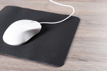 Sticker - Computer mouse with mousepad on wooden table, closeup