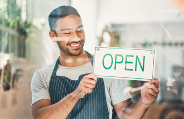 Wall Mural - Window, waiter and coffee shop with open sign or poster in small business, cafe or bistro. Male person, hospitality and happiness as barista, entrepreneur or employee for welcome as restaurant staff