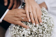 © Tetiana - Newly wed couple's hands with wedding rings on a bouquet.
