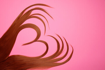 Poster - Red hair strands in shape of heart on pink background, top view. Space for text