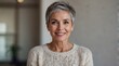 © VistaVisions - Close up image of happy good looking elegant senior woman wearing warm cozy sweater jumper, pearl earrings and short pixie cut stylish haircut in good mood sitting in living room, smiling broadly