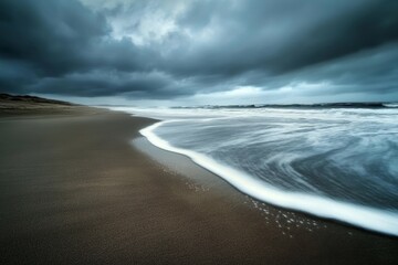 a stormy sky hangs over a sandy beach with whitecaps and waves crashing on the shore.