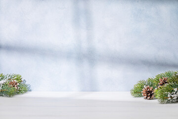 Aufkleber - Christmas template featuring snowy fir tree branches on a table with shadows and sun glares softly falling on the wall