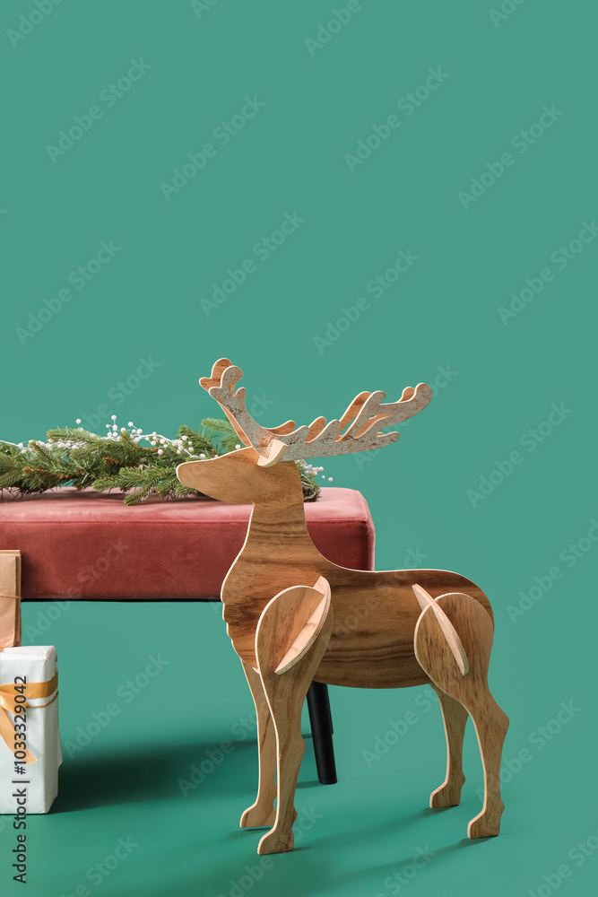 Soft bench with Christmas branches and wooden reindeer on green background