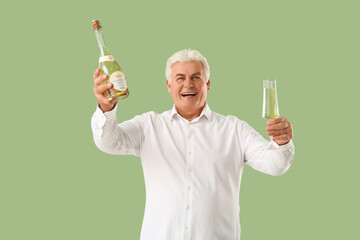 Sticker - Happy senior man with bottle and glass of champagne celebrating Christmas on green background