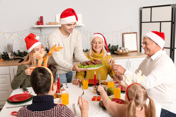 Poster - Young man putting food on dining table with his family at home on Christmas eve