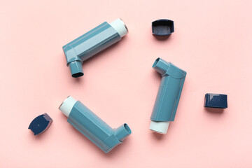 Wall Mural - Inhalers and lids on pink background, closeup