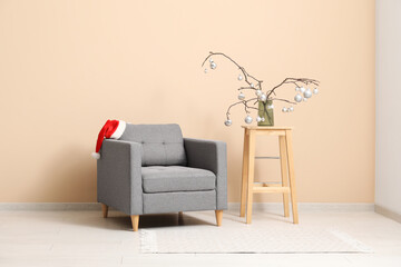 Wall Mural - Interior of living room with stool, armchair and Christmas decoration near beige wall