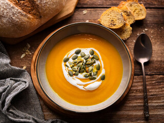 Delicious pumpkin soup with a sprinkle of pumpkin seeds, paired with freshly baked pumpkin bread, ai.