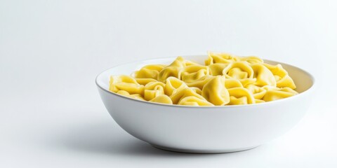 Aufkleber - Fagottini tortellini pasta in a white bowl set against a white background, softly lit, studio shot, angled view, copy space.