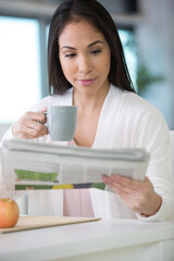 happy woman holding newspaper and coffee cup