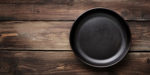 Aufkleber - Black plate on a brown wooden table, Copyspace for text, Vintage style.