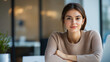 © Yana Zolotova - Smiling woman sitting at desk in casual office environment