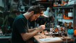 © fotofabrika - A young man meticulously working on a detailed model at a well-organized workbench in an evening-lit workshop