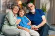 © Guys Who Shoot - a bright living room with sofa grandfather and grandmother sitting with grandson on sofa hugging looking at camera happy family
