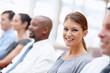 © STEEXBuyout/peopleimages.com - Portrait, smile and businesswoman in audience for workshop, seminar or learning in conference. Employees, happy or proud intern in presentation for staff training, development or convention in office