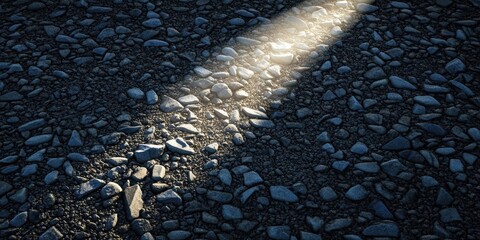 Poster - Light with a bright projection on a surface of small dark stones.