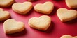 © HN Works - Heart-shaped sugar cookies against a red backdrop.
