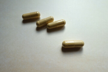 Close view of four beige capsules of Saccharomyces boulardii probiotic dietary supplement