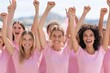 © Jane_S - A group of young women raising their arms in celebration, wearing matching pink shirts. The image represents unity, empowerment, and joy as they participate in an outdoor event.