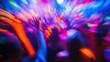 © logyartstudios - Blurred image of a crowd of people dancing at a party under colorful lights.