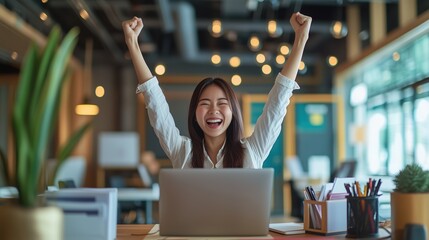 Happy Woman Celebrating Success in Office Environment. Joyful woman in an office celebrates her success with raised arms, showcasing a vibrant workspace filled with motivation and positivity.