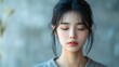 © Paul - A sorrowful young Asian woman in 3D style, closed eyes, reflecting disappointment, subtle soft light on a minimalist light background, focus on human emotions