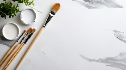 A collection of paintbrushes placed alongside pots of white paint on an artist's surface, symbolizing the initial stages of a creative endeavor in art-making.