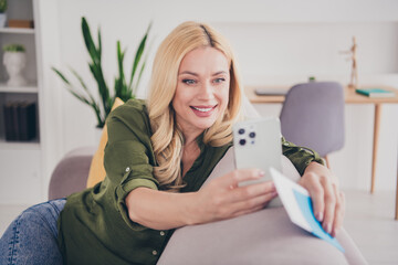 Photo of lovely adorable woman preparing fly abroad sitting sofa indoors weekend travel trip tour