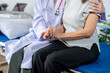 © Apichat - Doctor comforting patient by holding her hand in hospital room