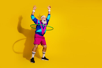 Wall Mural - Full length photo of funny aged sportsman hula hoop empty space retro uniform isolated on yellow color background