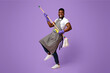 © Prostock-studio - Funny African Man Using Mop Handle As Guitar, Having Fun During Cleaning. Posing Over Pink Background In Studio, Copy Space
