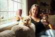© Malambo/peopleimages.com - Woman, portrait and coffee with dogs on sofa for relax, bonding with animals or happy in home. Person, chihuahua pets or together on couch with caffeine, smile and comfortable with companion in house