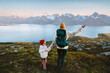 © EVERST - Family adventurers mother and child hiking in Norway exploring wild trails in mountains travel healthy lifestyle vacations outdoor, mom with backpack and kid enjoying Lyngen Alps and fjord view