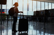 © Song_about_summer - airport check-in and baggage drop-off counter, woman waiting with luggage, passenger silhouette