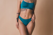 © deagreez - Cropped photo of charming slim model wearing stylish lingerie isolated on beige color background