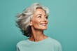 © Markus Schröder - Portrait of a glad woman in her 50s wearing a breathable golf polo while standing against soft teal background