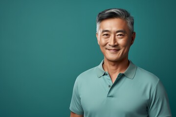 Sticker - Portrait of a happy asian man in his 60s donning a classy polo shirt over soft teal background